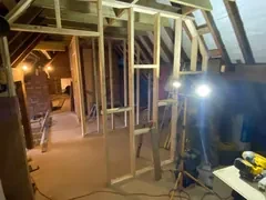 Timber stud walls framed out in a loft under site lights